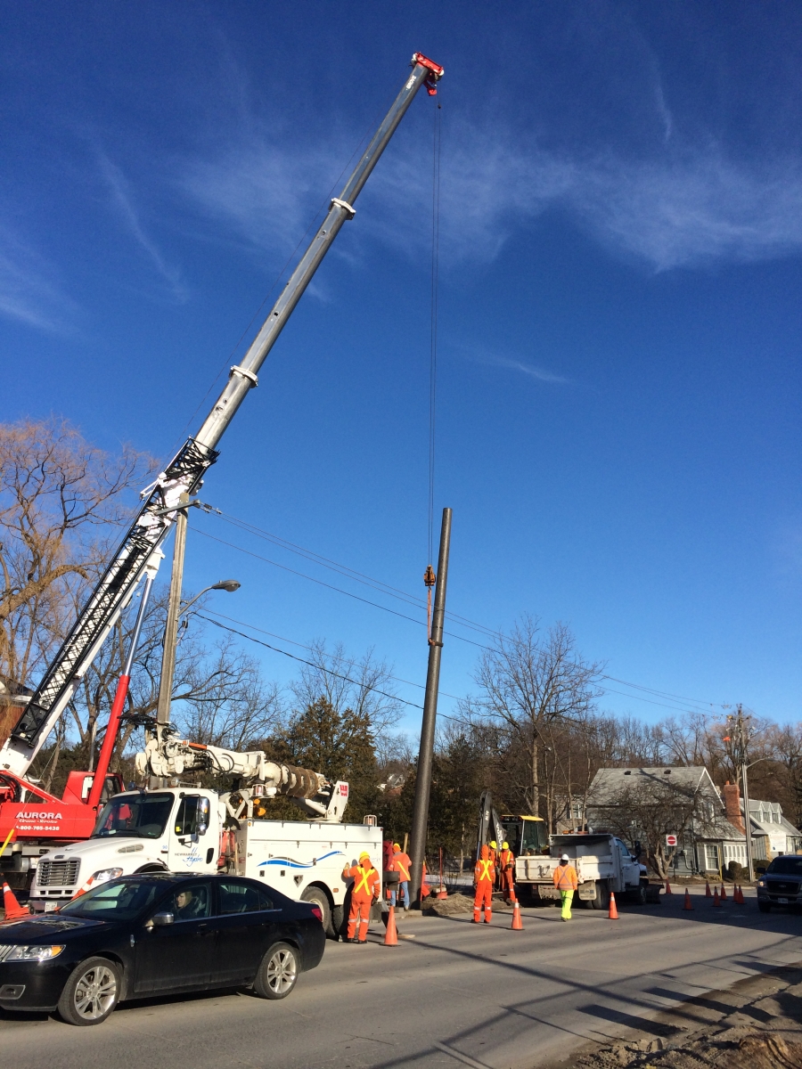 Construction workers installing an electric pole