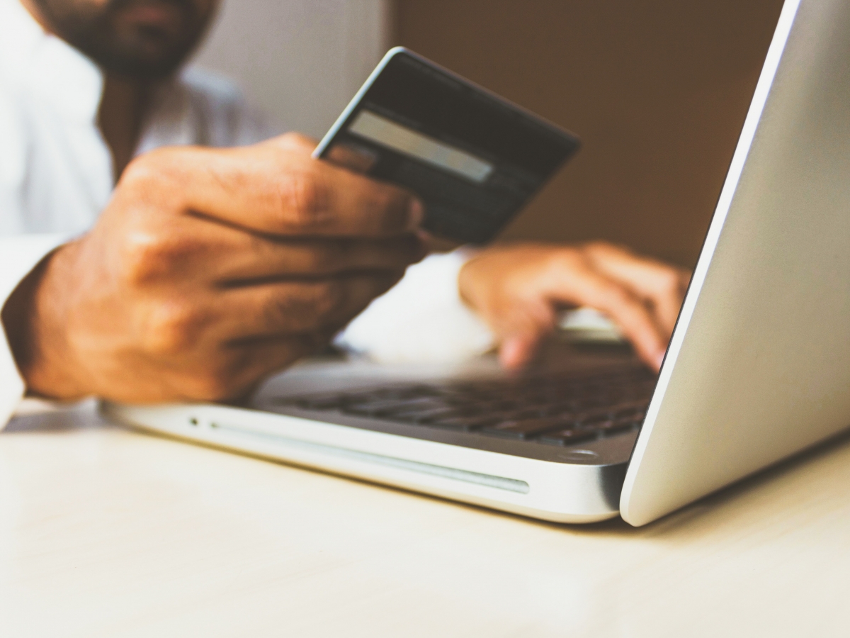 Payment Options person holding credit card in front of laptop